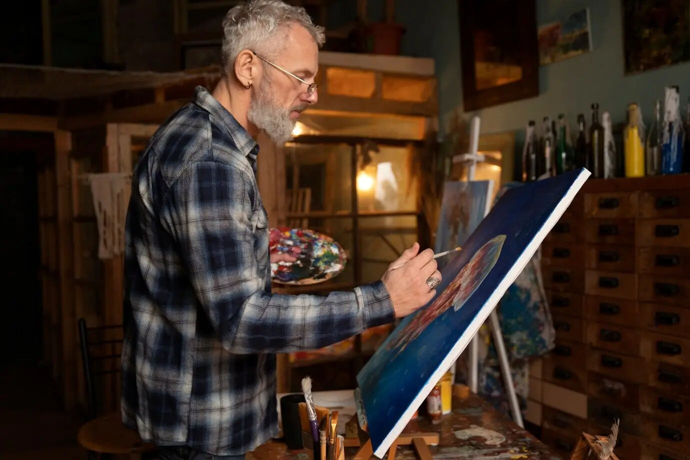 屋内での年配の画家のミディアムショット