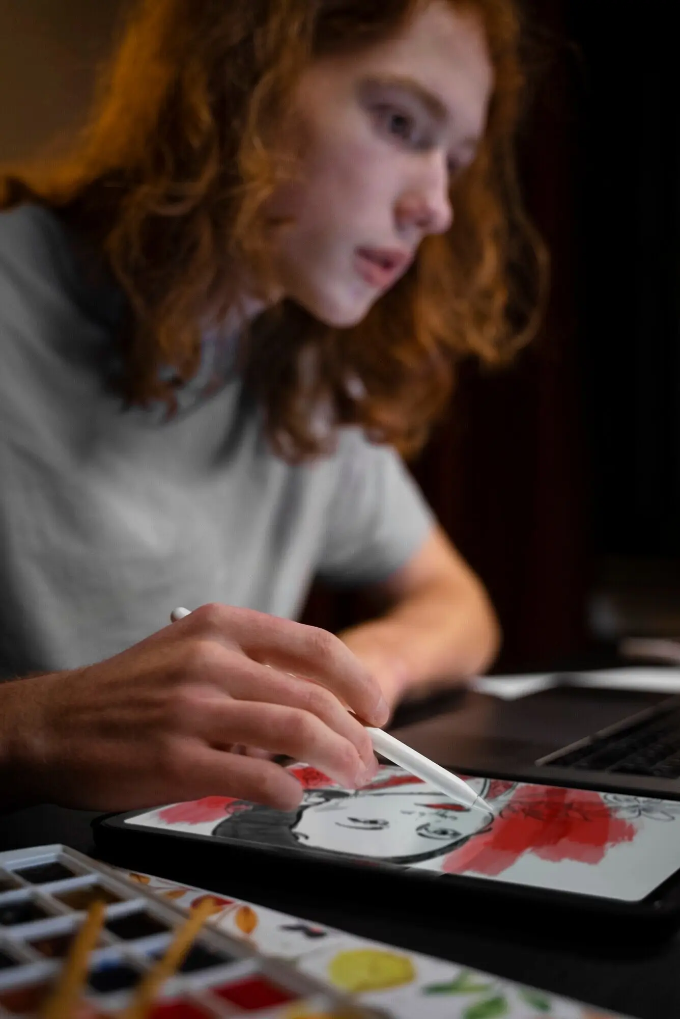 横から見た、iPadで描いている女性